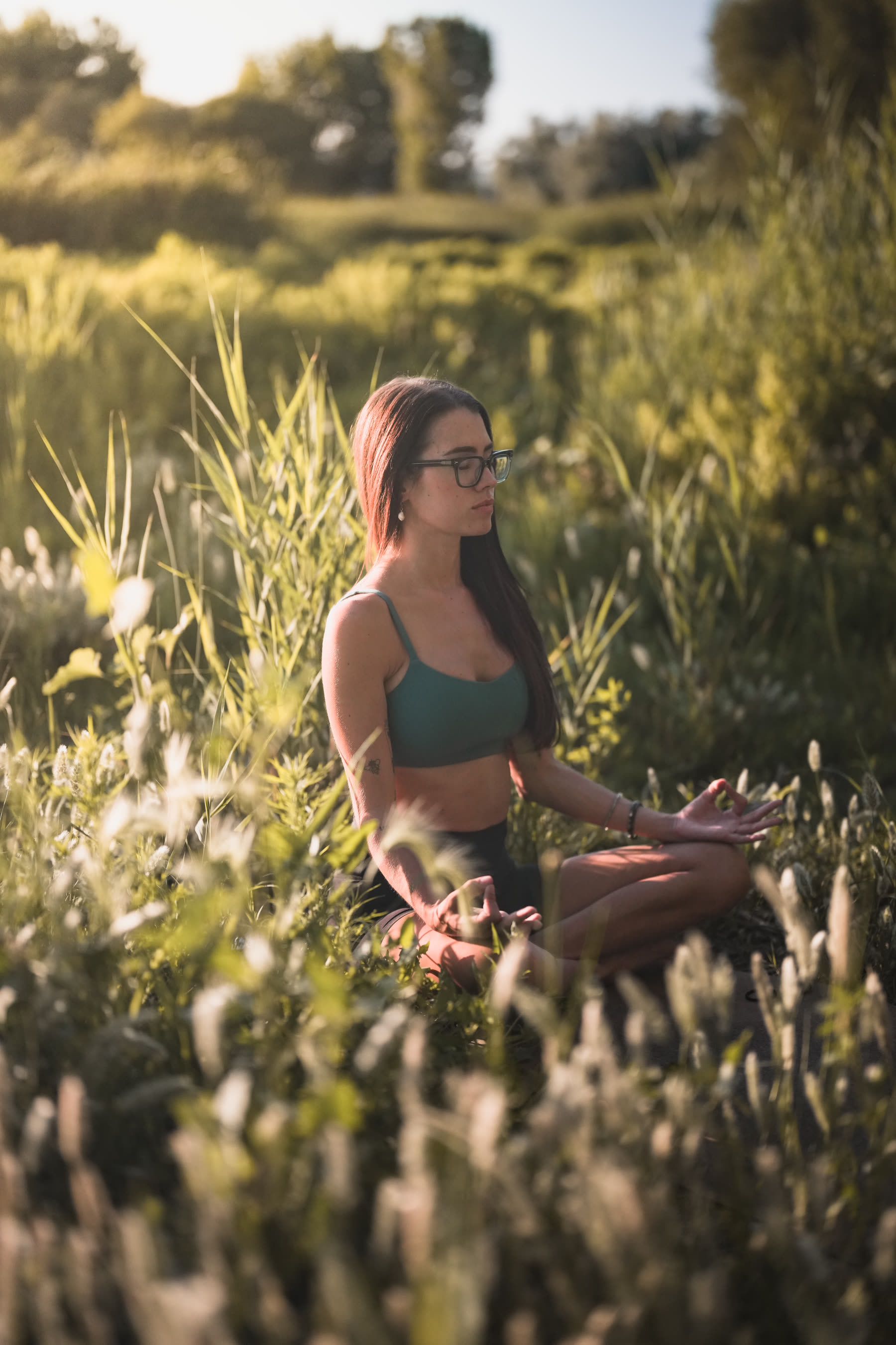 Editorial yoga shoot, seated in tall grass