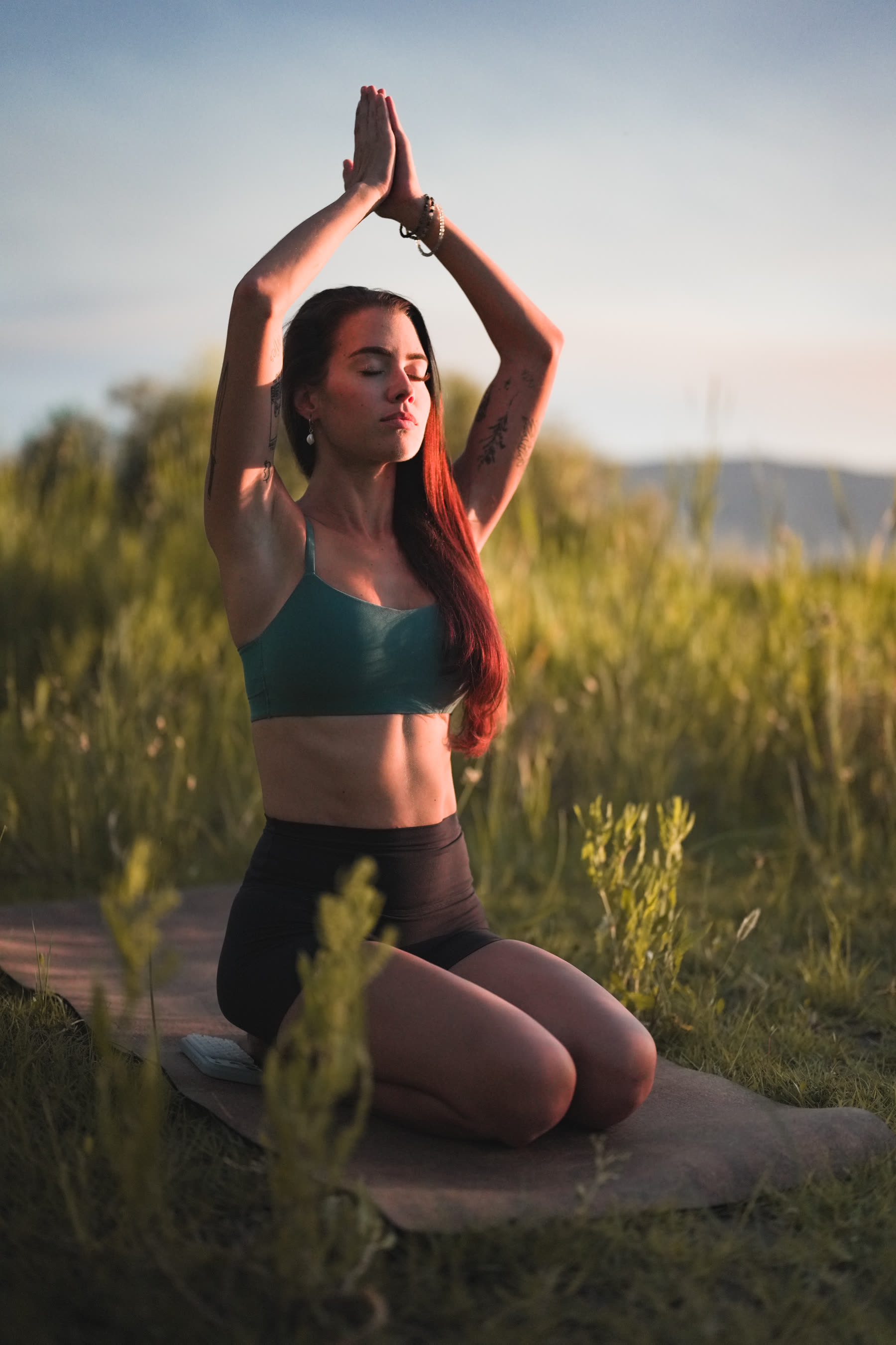 Editorial yoga shoot, arms raised at golden hour