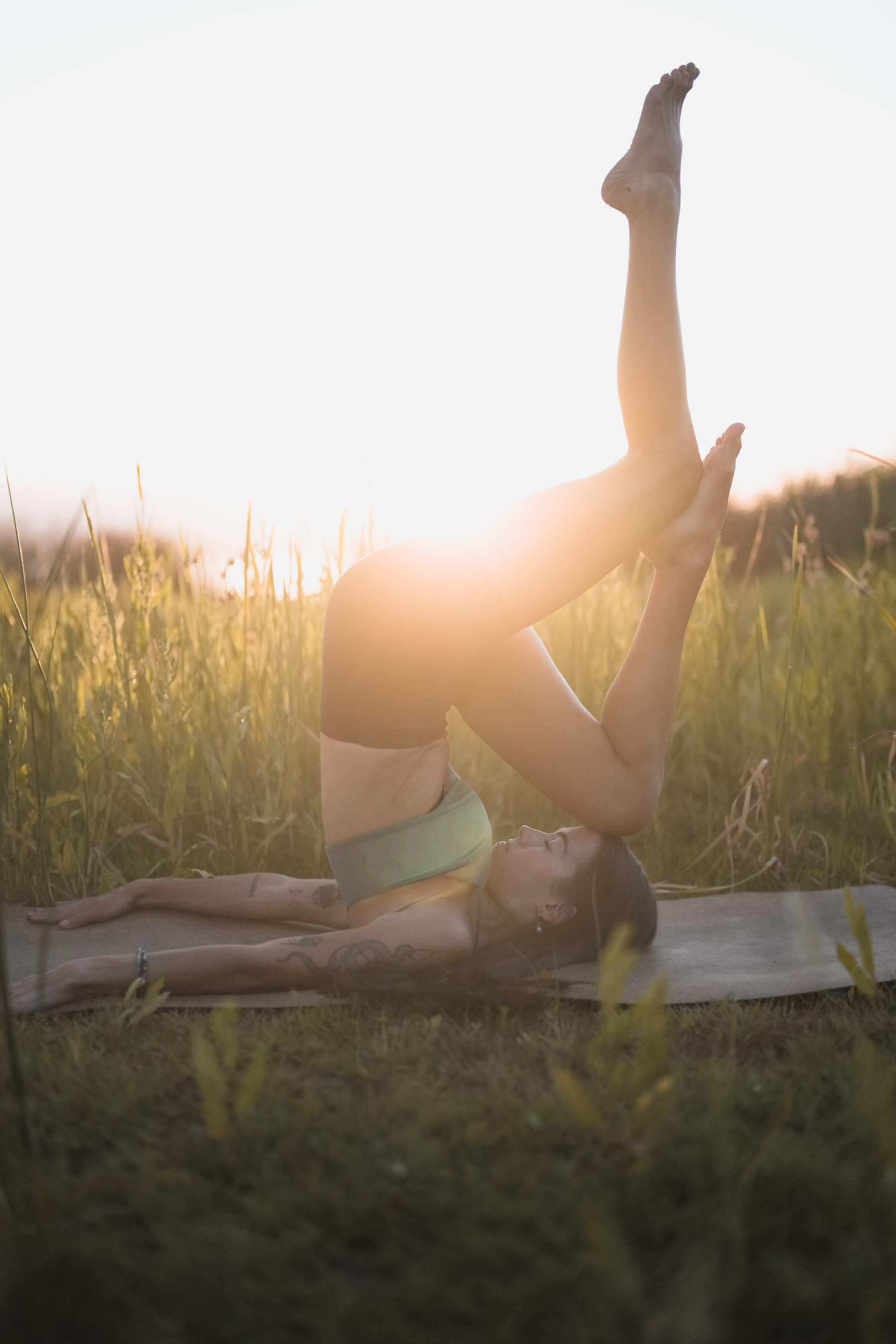 Yoga session, backlit shoulder stand